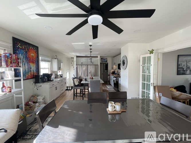 A modern kitchen with a dining table and chairs in the middle.