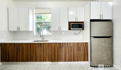A kitchen with wooden cabinets and a white fridge.
