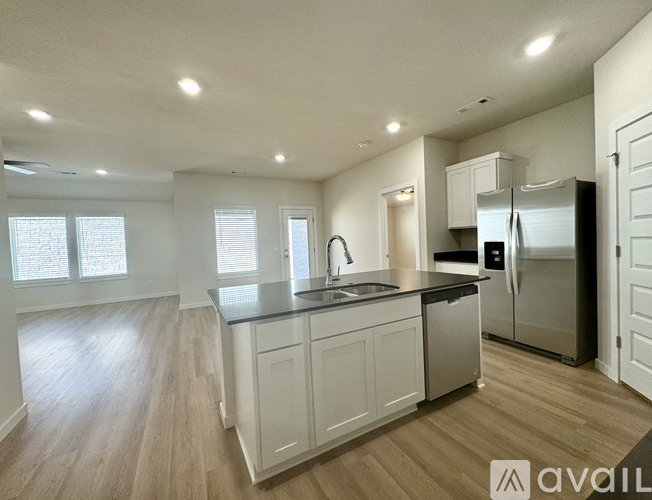 A kitchen with white cabinets and a black countertop.