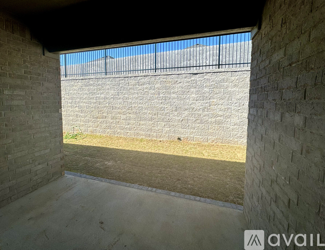 A view from inside a building looking out to a fenced area.