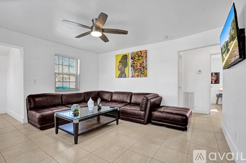 A living room with a brown leather couch and a glass coffee table.
