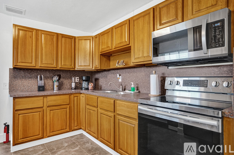 A kitchen with wooden cabinets and a stainless steel oven.