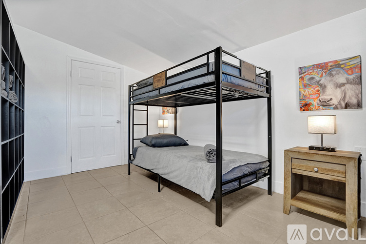 A bedroom with a bunk bed and a wooden nightstand.
