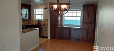 A kitchen with a granite counter top and wooden floors.