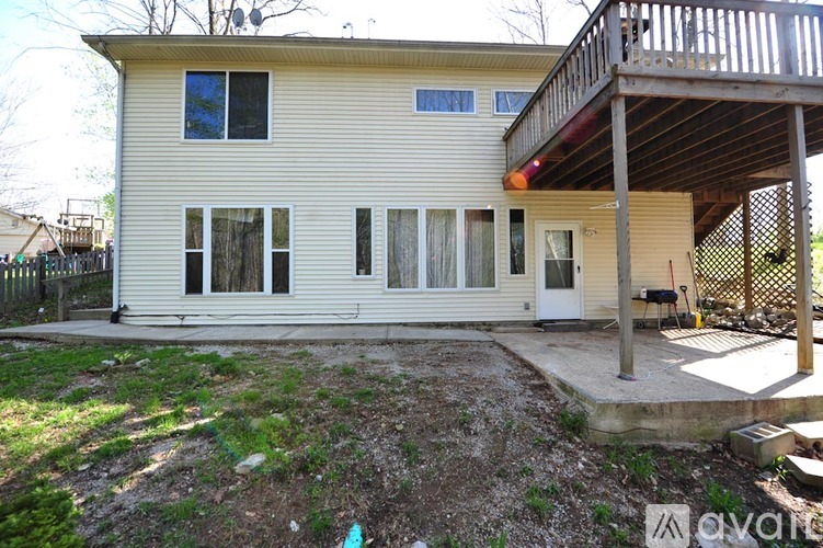 A two-story house with a balcony and a small backyard.