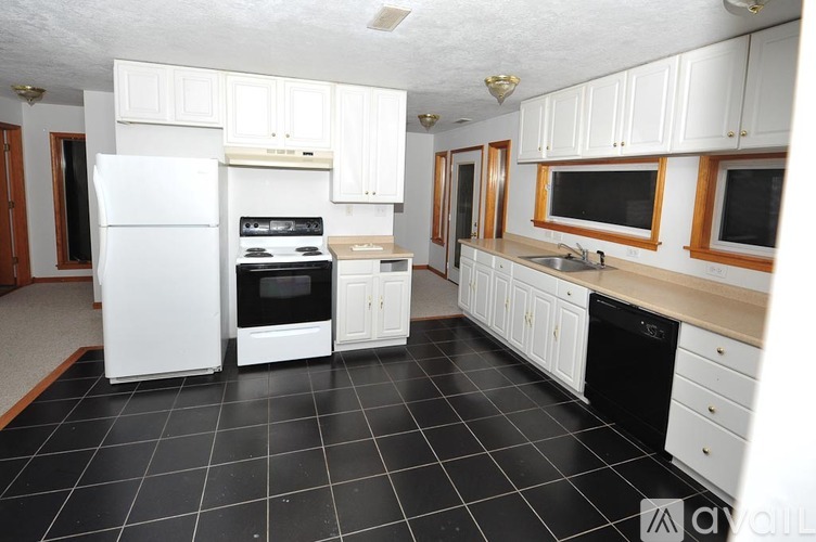 A kitchen with white appliances and cabinets.