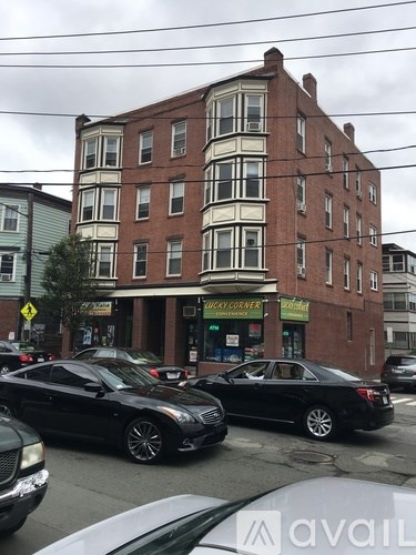 A black car is parked in front of a building with a sign that says "Sugar Corner".