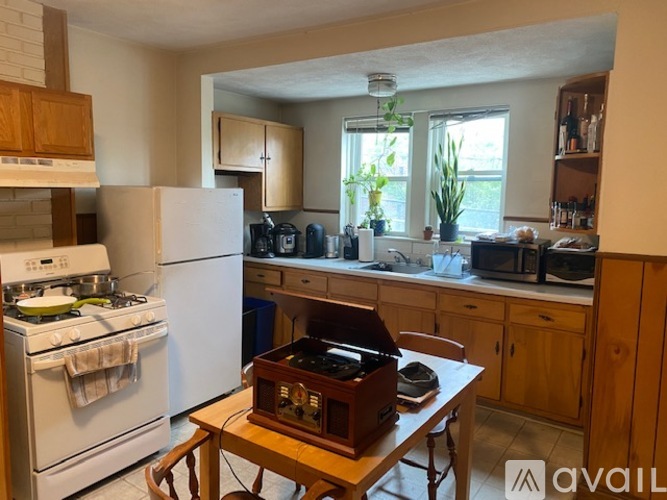 A kitchen with a white refrigerator and a white stove.