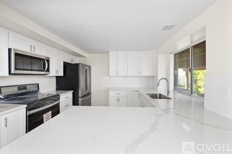 A kitchen with white cabinets and appliances.