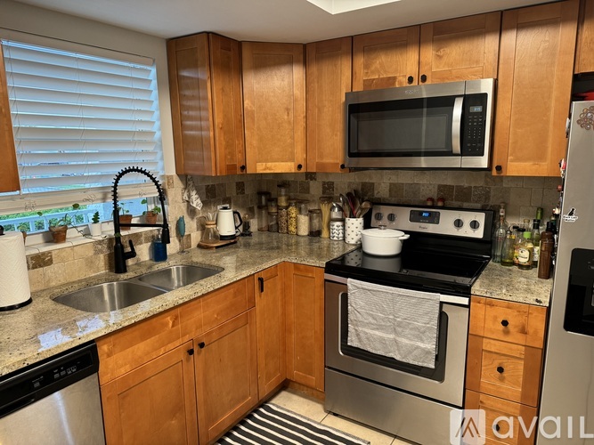 A kitchen with wooden cabinets and stainless steel appliances.