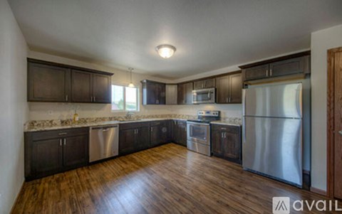 A kitchen with wooden floors and stainless steel appliances.