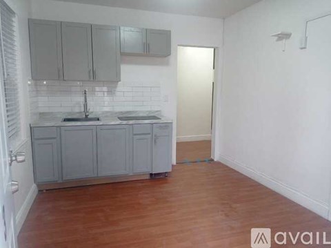 A kitchen with wooden floors and white walls.