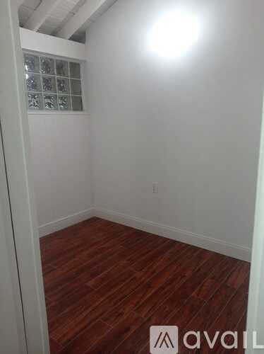 A room with wooden flooring and white walls.