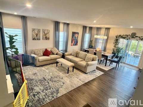 A living room with a large rug and a sofa.