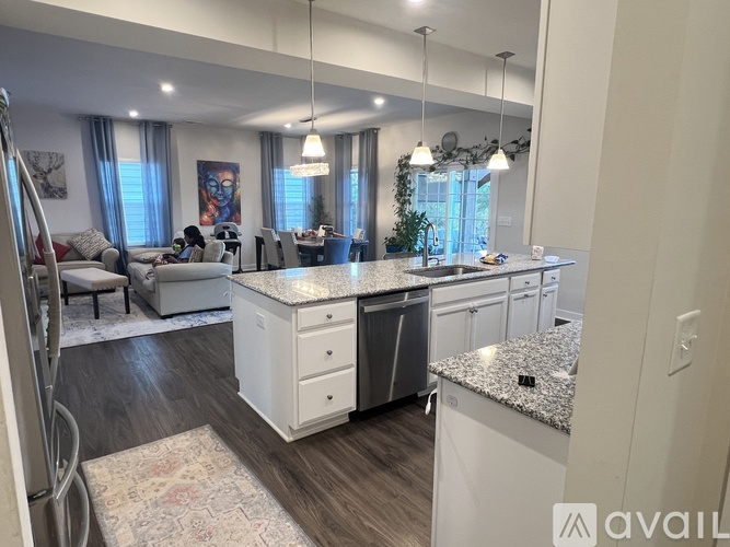 A modern kitchen with a large island and a dining area with a table and chairs.