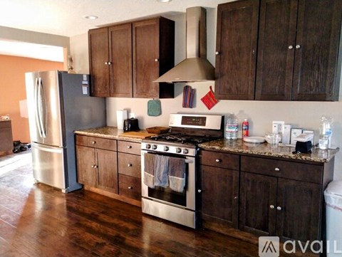 A kitchen with wooden cabinets and a stainless steel refrigerator.