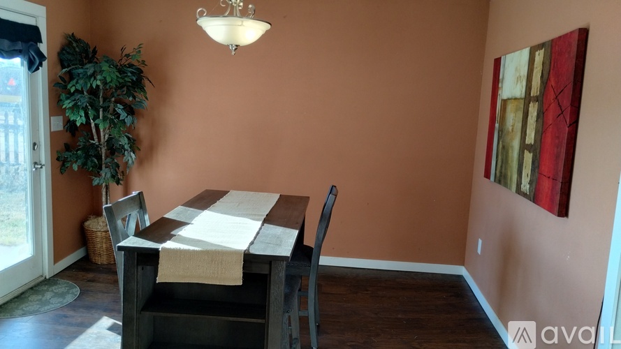 A dining room with a wooden table and chairs.