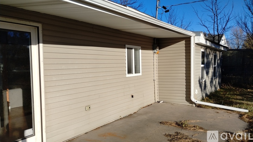 A house with a beige exterior and a small window is for sale.