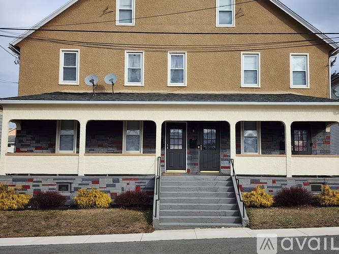 A two-story house with a brown facade and a grey roof.