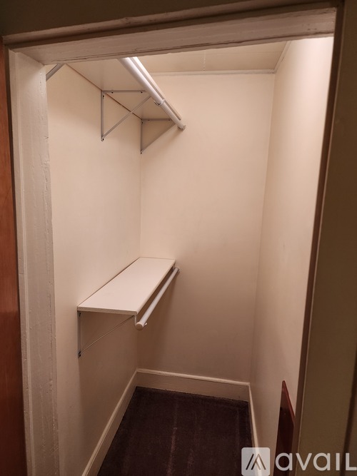 A small white closet with a shelf and a hanging rod.