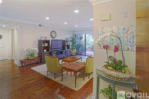 A living room with a wooden floor and a painting on the wall.