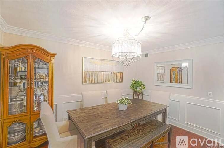 A dining room with a wooden table and chairs.