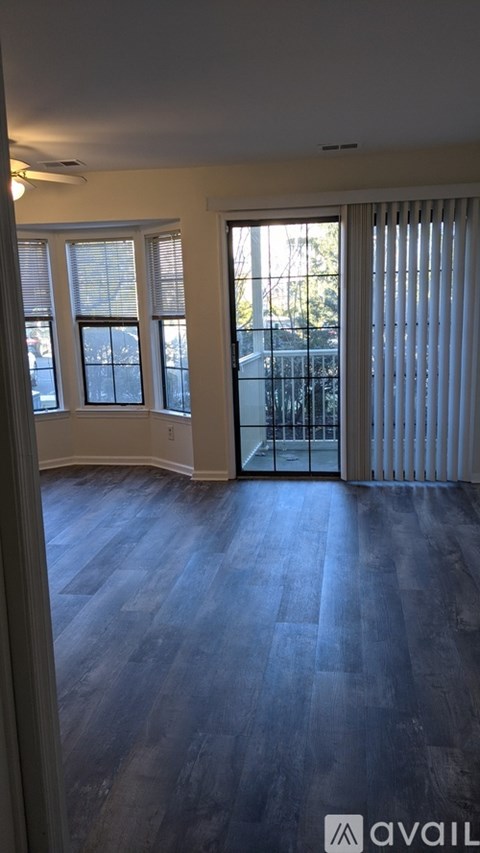 A room with a wooden floor and a sliding glass door.