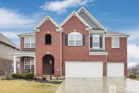 A brick house with a garage door and a window.