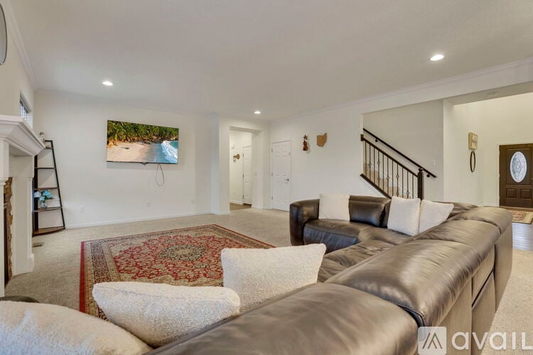 A living room with a large couch and a painting on the wall.