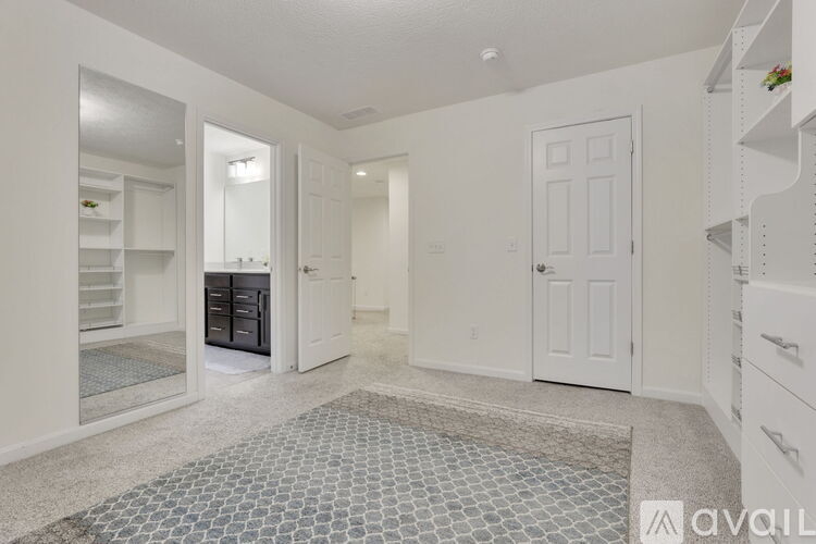 A spacious kitchen with white cabinets and a tiled floor.
