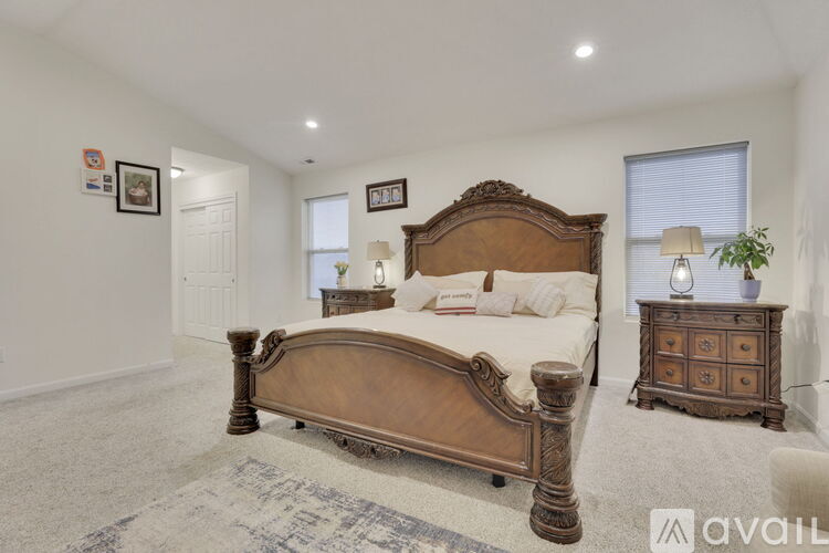 A bedroom with a large bed and a wooden dresser.