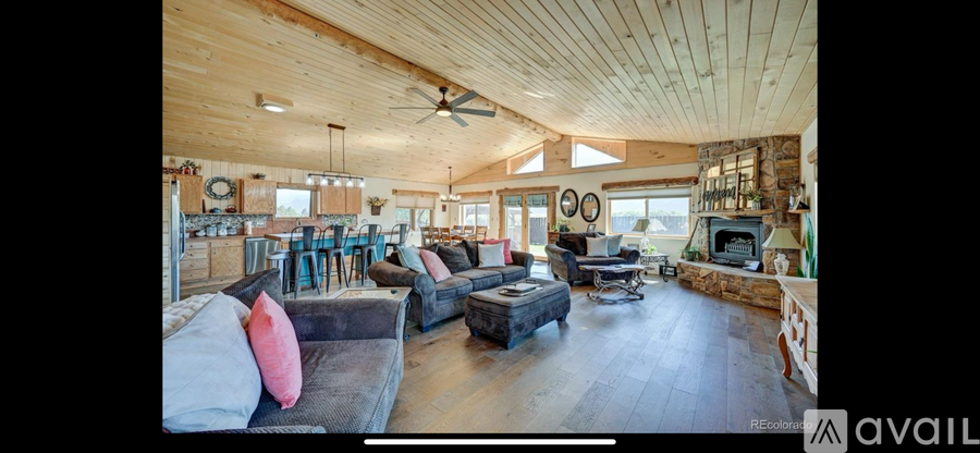 A spacious living room with a fireplace and a bar area.