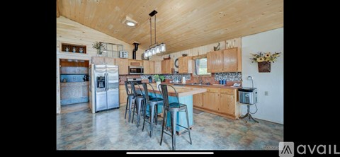 A kitchen with wooden cabinets and a large island.