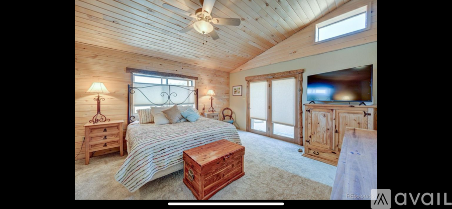 A bedroom with a bed, dresser, and ceiling fan.
