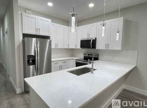 A modern kitchen with a large island and stainless steel appliances.