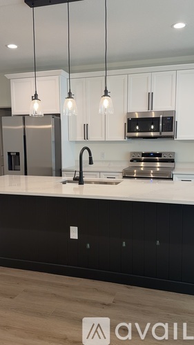 A modern kitchen with a white countertop and black cabinets.