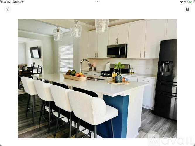 A kitchen with white and blue accents and modern appliances.