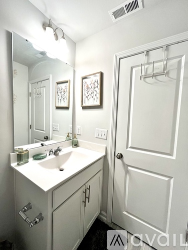 A white bathroom with a sink and mirror.
