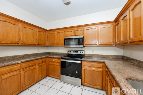 A kitchen with wooden cabinets and a granite countertop.
