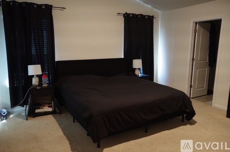A bedroom with a large bed and two lamps on side tables.