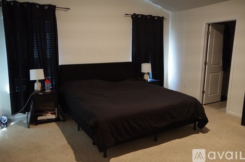 A bedroom with a large bed and two lamps on side tables.