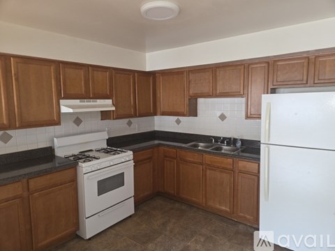 A kitchen with brown cabinets and a white stove top oven.
