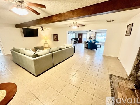 A living room with a couch and a television on the wall.