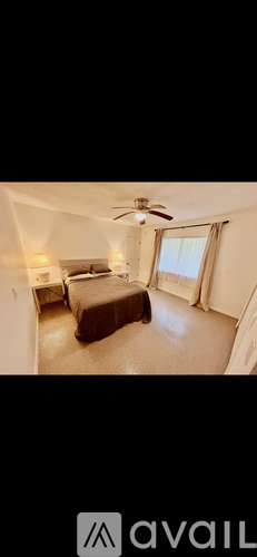 A bedroom with a bed and a ceiling fan.