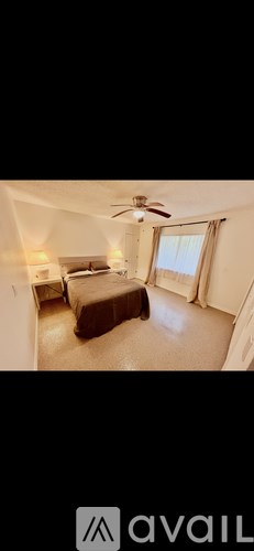 A bedroom with a bed and a ceiling fan.