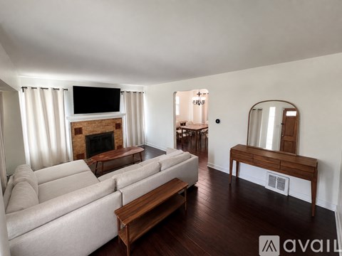 A living room with a white couch and a fireplace.