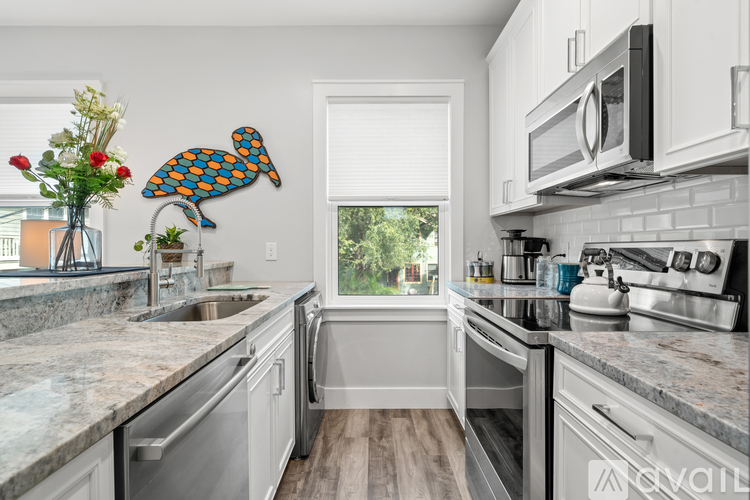 A kitchen with a white counter top and a window.