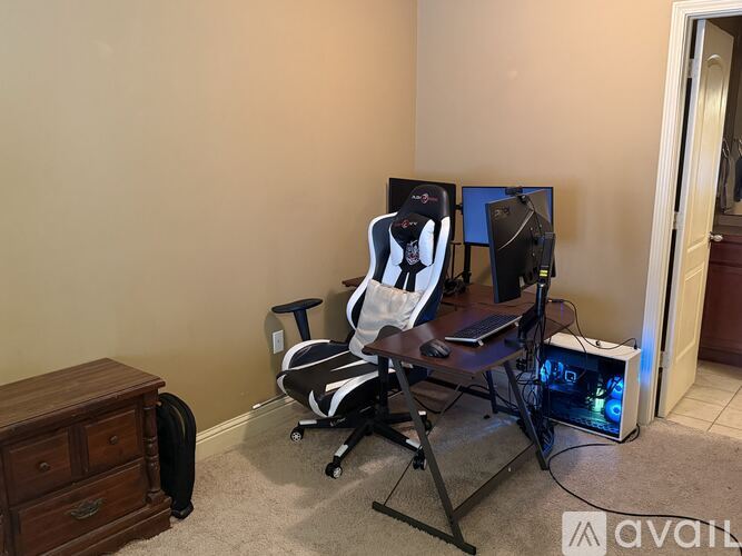 A gaming setup with a chair, monitor, keyboard, and mouse.