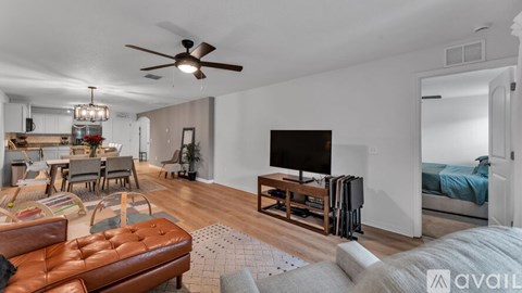 A living room with a brown leather couch and a flat screen TV.