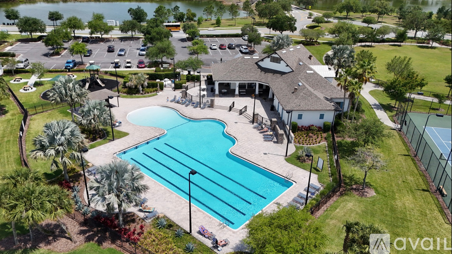 A large swimming pool surrounded by a grassy area and a building in the background.